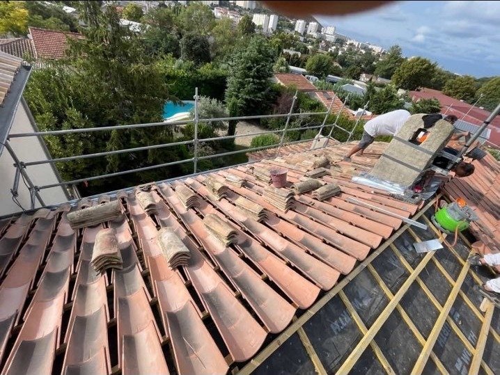Artisans de BGR Couverture posant des tuiles canal sur une toiture à Nîmes